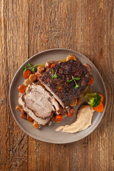 Whole roasted pork neck, stewed in wine with vegetables.