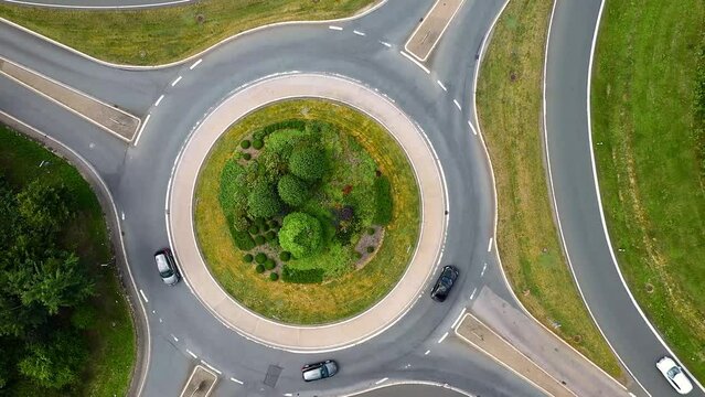 Aerial drone footage of a roundabout with driving cars
