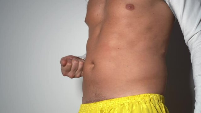40-year-old man checks the state of his body after sport activities and gym exercises for the abdominal muscles - getting ready for summer after gaining weight