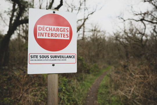 Un panneau en for&ecirc;t avec &eacute;crit dessus d&eacute;charges interdites