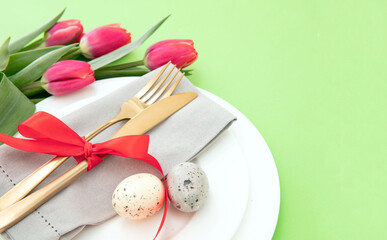 Easter table setting, Yellow Spring flowers, napkin and golden cutlery on white plates