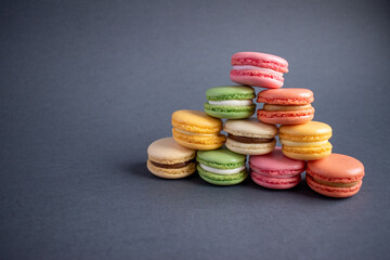 A macaroon is a French pastry made with egg whites, sugar, and ground almonds. Sweet French macaroons on a dark background.