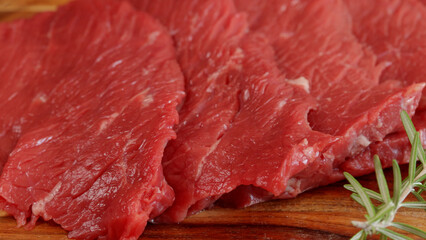  plusieurs steaks de boeuf crus, en gros plan, sur une planche à découper