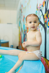 Little boy 2 years old are in the pool. Swimming lessons for young children.