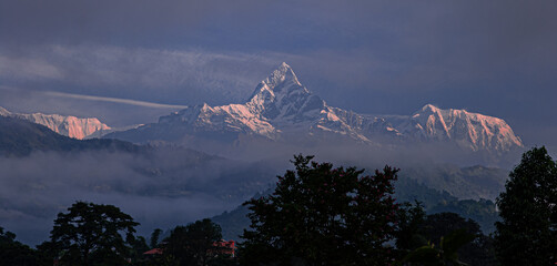 View of Machapuchare (Fish-Tial) mountain at foggy sunrise, situated in the Annapurna mountain...