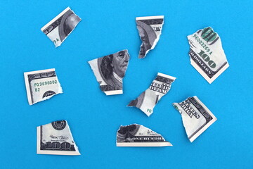 A torn dollar bill lies on a blue background.