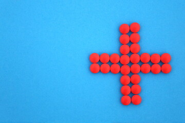 Pink pills with plus sign or cross.