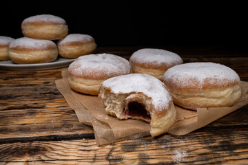 Pączki deep-fried Polish doughnuts. Celebrating Fat Thursday, Tłusty czwartek feast, traditional day in Poland. Pączek food, powdered sugar topped and filled with rose hip jam.