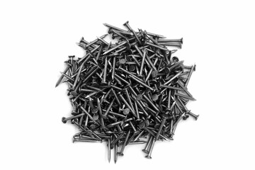 A pile of large iron nails lie on a white background.	