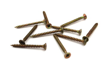 A lot of self-tapping screws lie on a white isolated background.	
