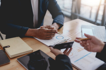 Business people meeting pointing graph and chart to analyze financial and marketing investment.