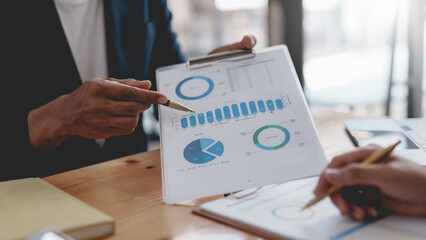 Business people meeting pointing graph and chart to analyze financial and marketing investment.