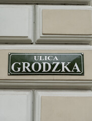 Grodzka street name sign in the Old Town district of Krakow, Poland. Information plate on a building wall in Kraków.