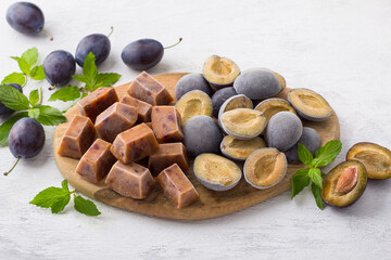 Plum freezing methods: plum puree and plum halves garnished with fresh plums and mint on a light gray background