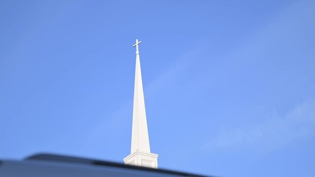Low angle shot of the church steeple with a blue sky background
