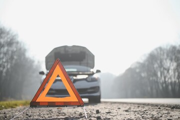 Broken car concept, breakdown triangle on road