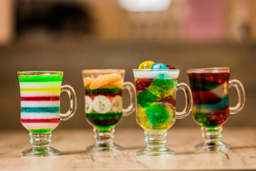 colorful jelly layered desserts with fresh fruits in glasses