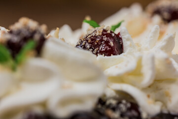 whipped cream topped with a glazed cherry close- up
