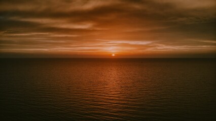 Fototapeta na wymiar Mesmerizing orange sunset over the horizon of the sea