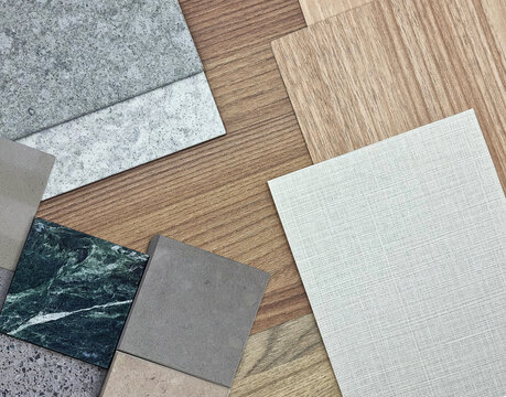 interior material board containing multi pattern of wooden laminateds, grainy quartz stones, grey interior fabric wallpaper, green marble, artificial stone samples. close up or macro view. mood board.
