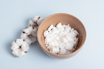 Soy or coconut wax in bowl. Cotton flowers and wax flakes for candle making