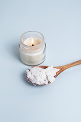 Handmade candle and soy or coconut wax on spoon. Wax for making candles
