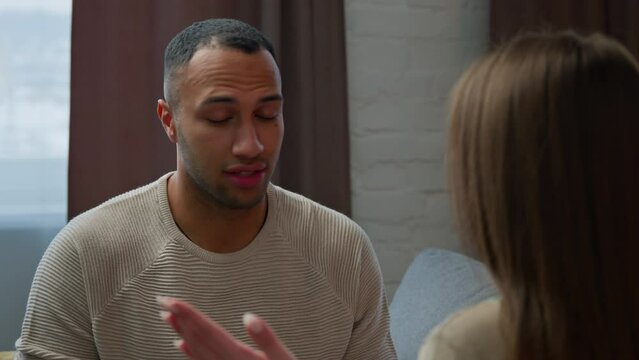 Back view unrecognizable woman talking with jealous african american man two spouses arguing at home married multiracial couple have conflict family quarrel disagreement problem relationship breakup