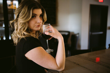 Beautiful blue-eyed blonde drinking in speakeasy lounge