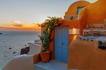 Zelfklevend Fotobehang Orange house against the backdrop of sunset on the island of Santorini. Greece. © Svetlana