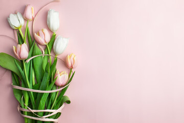 Composition of pink and white tulips, ribbons on a pink background. Tulips bouquet, spring flowers. Content for Birthday, Valentines Day, Womens day. Flat lay, top view, close up, copy space