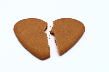 One broken gingerbread heart. Concept of ending love. Large crack in the middle. Isolated on a white background. 