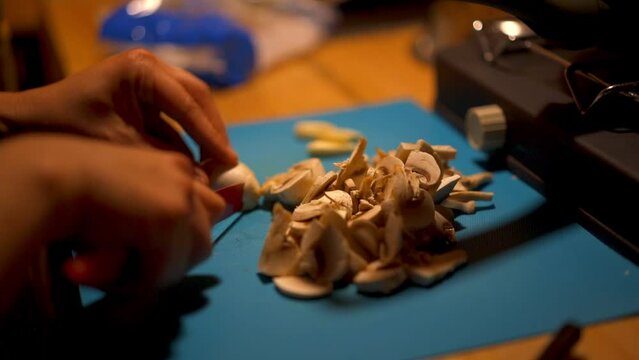 Closeup slow motion of a person slicing a mushroom