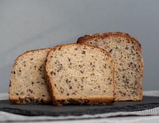 Rye bread with seeds lies on a dark board on a light table. My home bakery. Organic whole grain bread. Bio Dinkel Brot. Healthy bread. complex carbohydrates. health diet. Healthy breakfast.