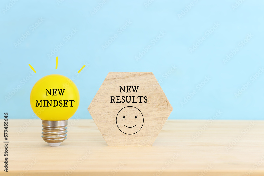 Poster light bulb with the text new mindset in on wooden table