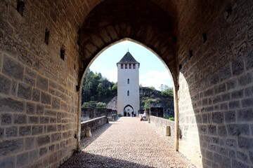 an arched passageway leads to the entrance to a castle tower © Stefan/Wirestock Creators