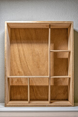 A vertical box or drawer with partitions, shelves, for distributing and storing small items or artifacts, as a background or template for your creativity. Interior item, showcase, storage system.