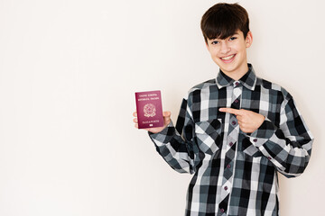 Young teenager boy holding Italy passport looking positive and happy standing and smiling with a...