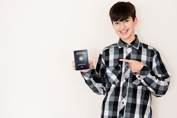 Young teenager boy holding Liechtenstein passport looking positive and happy standing and smiling with a confident smile against white background.