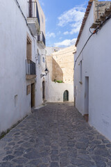 Fototapeta na wymiar Streets of the old town of Ibiza, with the typical white houses of the island, on a sunny day and without tourists