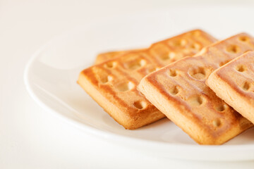 Rectangular sweet cookies, on white plate, side view, selective focus