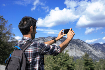 Hiker takes a photo with his mobile phone.