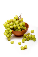 A bunch of ripe grapes in a plate on a white background