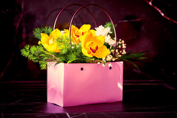 a bouquet of flowers is in a pink basket