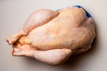 Whole raw chicken on white background. Top view.