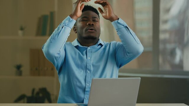 Tired sad angry African American man businessman manager entrepreneur working with laptop at office has computer problem broken device send wrong email message bad news or crash mistake error failure