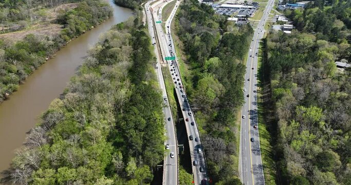Aerial view flying above the I-75 and I-16 interstate interchange in downtown Macon, Georgia beside a river 