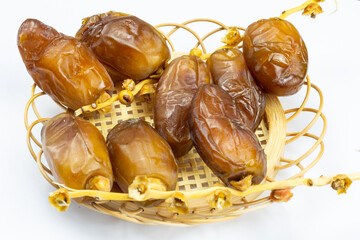 Close-up of Algerian royal dates on a wooden plate on a white background. Ramadan concept.