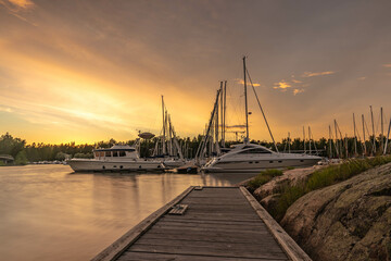 Amazing sunset over the harbor in Finland. A landscape with sunset ,boats in the harbor and an amazing sky that gives a beautiful and fairy-tale atmosphere. 