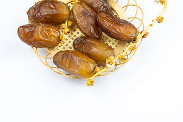 Close-up of Algerian royal dates on a wooden plate on a white background. Ramadan concept.