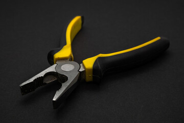 Used combination pliers on black surface